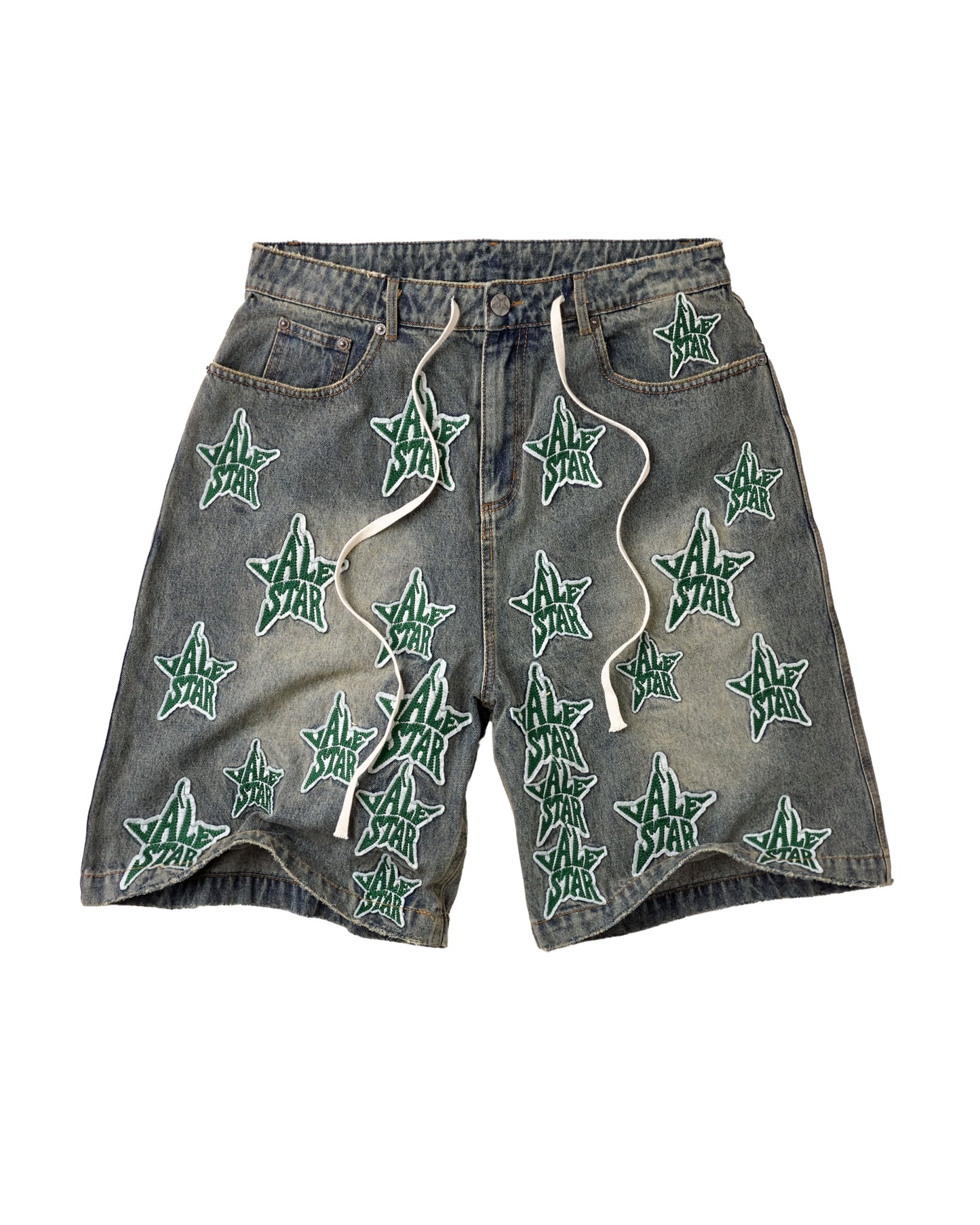 A pair of faded gray denim shorts featuring an all-over pattern of embroidered green five-pointed stars with white outlines and white drawstrings, displayed flat against a white background.